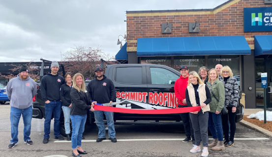 schmidt roofing workers standing in front of truck with red ribbon